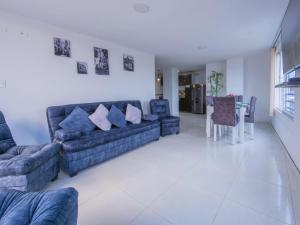 a living room with blue couches and a table at Amplio Y Lujoso Apartasuite En El Centro in Cartago