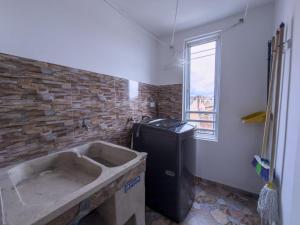 a bathroom with a sink and a brick wall at Amplio Y Lujoso Apartasuite En El Centro in Cartago +18 photos