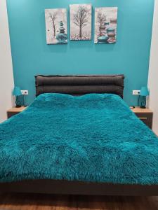 Un dormitorio azul con una cama con una pared azul. en Linda, en Tiflis