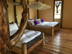 RubuguliにあるMigogo gorilla lodgeの木製の床の部屋にベッドが2つあります