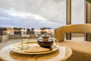 a plate with a tea pot and a glass at Petra Pillars Luxury Hotel in Petra