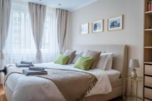 The GOR Apartment في كيسكيميت: غرفة نوم بسرير ذو شراشف بيضاء ومخدات خضراء