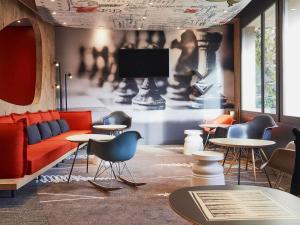sala de estar con sofá, mesas y TV en ibis Toulon La Seyne sur Mer, en La Seyne-sur-Mer