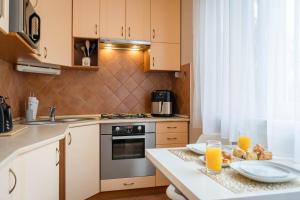 a kitchen with a table with two glasses of orange juice at The GOR Apartment in Kecskemét
