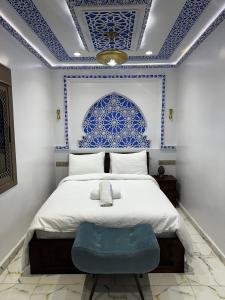 a bedroom with a bed with a blue and white ceiling at Dar Ouadie the pearl stay in Chefchaouen