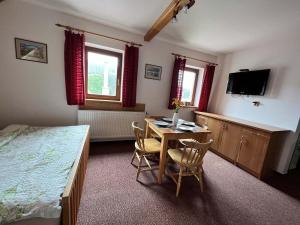 a bedroom with a bed and a table and chairs at U Javoru in Albrechtice v Jizerských horách