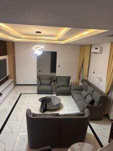 een woonkamer met een bank en een tafel bij Next Level Apartments and Suites in Ibadan