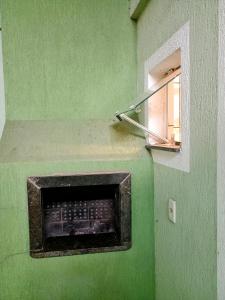 a green wall with a window in a room at Apartamento zimbros bombinhas in Bombinhas