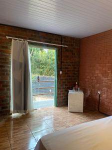 a bedroom with a bed and a door with a window at MOVE quartos de hotel in Pipa