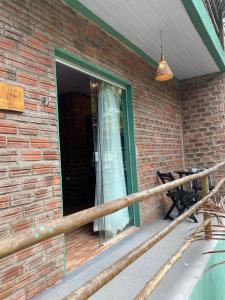 a window on a brick house with a bench on a porch at MOVE quartos de hotel in Pipa +2 photos