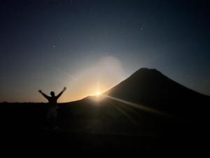 a man with his arms up in front of a mountain at Funco Du Santos in Portela