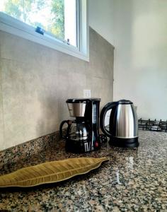 een koffiezetapparaat en een koffiepot op een aanrecht bij Viento Sur 2 in Estancia El Polomo