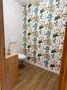 a bathroom with a toilet and a shower curtain at Au Petit Casino in Vuillafans +9 photos
