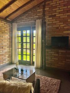 Quiosque Família Chalé Garça في جوانوبوليس: غرفة معيشة مع أريكة وطاولة قهوة