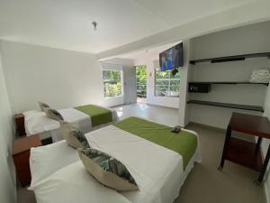 a bedroom with two beds and a flat screen tv at Hotel Parador del Gitano in Doradal +61 photos