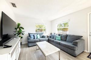 a living room with a couch and a tv at 2bd 2ba Beachside E 3Min to Beach Pool! in Clearwater Beach
