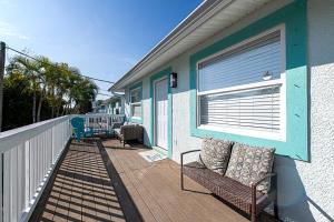 a porch with a bench and a window on a house at 2bd 2ba Beachside E 3Min to Beach Pool! in Clearwater Beach