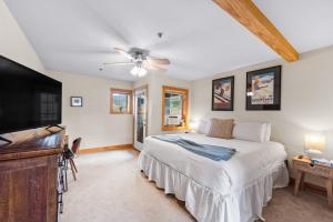 La Riva Del Lago Unit 204 في ديلون: غرفة نوم مع سرير وتلفزيون بشاشة مسطحة