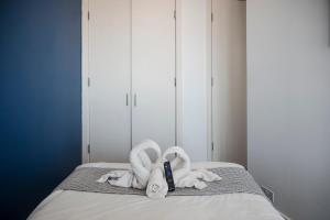 a bed with two towels and a bottle of shampoo at Bull Ring Apartment City Views Free Parking in Birmingham