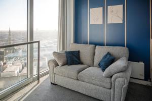 a living room with a couch and a large window at Bull Ring Apartment City Views Free Parking in Birmingham
