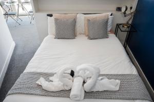 a bed with two swans towels on it at Bull Ring Apartment City Views Free Parking in Birmingham +33 photos