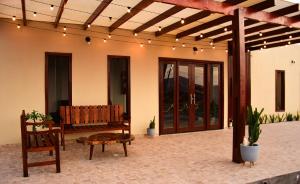 a patio with a bench and a table and chairs at Hotel Ipe in Barreirinhas