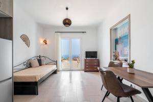 a bedroom with a bed and a dining room with a table at Manolia View Mykonos in Tourlos