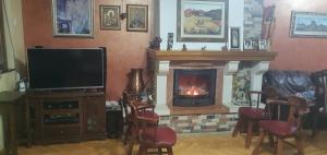 a living room with a fireplace and a television at Vila Anika in Podgorica +11 photos