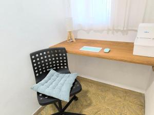 una sedia nera posta sotto una scrivania di legno di Casa Dace Renovated Studio - Fast Wi-Fi, Near Ocean, Ideal for Long Stays a San Nicolás