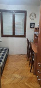 a room with a table and chairs and a clock on the wall at Vila Anika in Podgorica