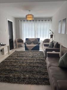 una sala de estar con un sofá y una alfombra en Da Vila, en São Paulo