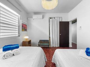 a bedroom with two beds with towels on them at Marley n Enzos Surf Shack in Aguadilla