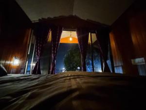 Pawan leke cottage في Kolvan: غرفة نوم مع نافذة مطلة على شجرة +صورتان