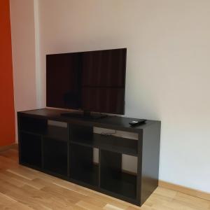 a black entertainment center with a flat screen tv at Bahnhofstraße III Apartment in Straubing +6 photos
