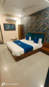a bedroom with a large bed with blue pillows at Hotel VR Villa in Vadodara