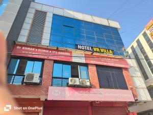 a building with a hotel sign on top of it at Hotel VR Villa in Vadodara