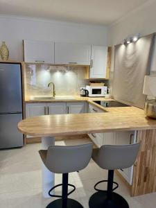 eine Küche mit einer Holztheke und zwei Barhockern in der Unterkunft Ali'i Tahiti in Papeete