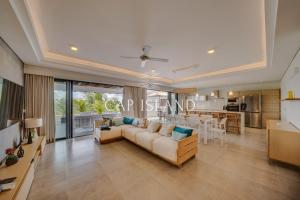 a living room with a couch and a table at Penthouse vue piscine lagon, 200m de la plage in Mont Choisy