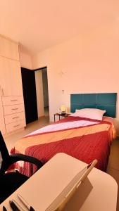 a hotel room with a bed and a desk and a table at Departamento moderno con alberca ideal para una escapada cómoda in Playa del Carmen