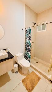 a bathroom with a toilet and a shower at Departamento moderno con alberca ideal para una escapada cómoda in Playa del Carmen +25 photos