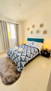 a bedroom with a bed with a blue and white comforter at Departamento moderno con alberca ideal para una escapada cómoda in Playa del Carmen