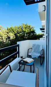 a balcony with a table and a glass of wine at Departamento moderno con alberca ideal para una escapada cómoda in Playa del Carmen