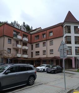 a large building with cars parked in a parking lot at Apartmán 19 MEZONET in Jáchymov