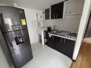 a kitchen with a stainless steel refrigerator and a sink at Alojamiento Cómodo y Hermoso en apartamento 7 personas Carnavales in Pasto