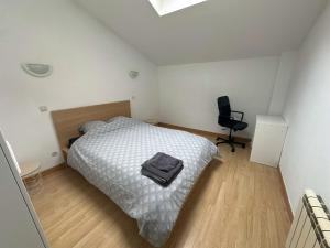 a bedroom with a bed and a chair in it at Chouette appart avec garage in Anzin