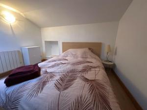 a bedroom with a large bed with a palm leaf bedspread at Chouette appart avec garage in Anzin