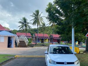 a white car parked in a parking lot with houses at Bleu Ocean in Deshaies
