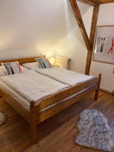 a bedroom with a large wooden bed with white sheets at Hirzhof SO Bike&Ski Ridehaus Ski In Ski Out in Auberg