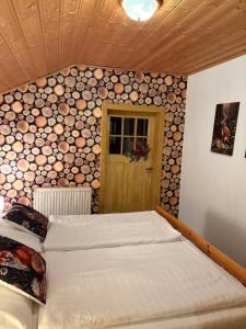 a bedroom with two beds and a wall of logs at Hirzhof SO Bike&Ski Ridehaus Ski In Ski Out in Auberg