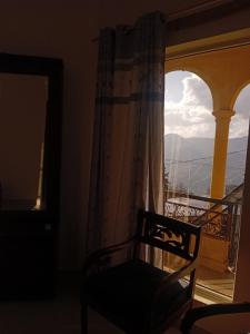 a chair in front of a window with a view at Paris pines Muree Bhurban in Bhurban